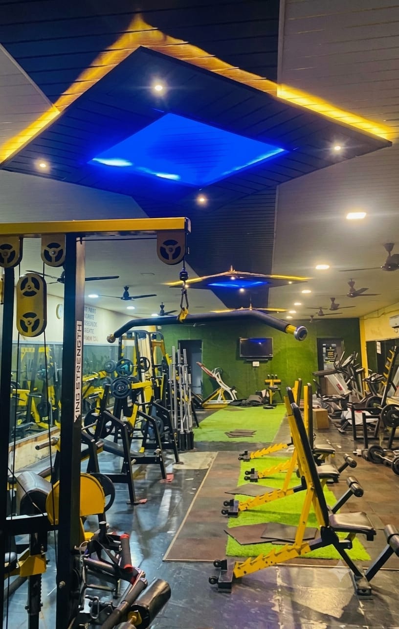 Bhandari Gym strength training area beneath blue ceiling lighting